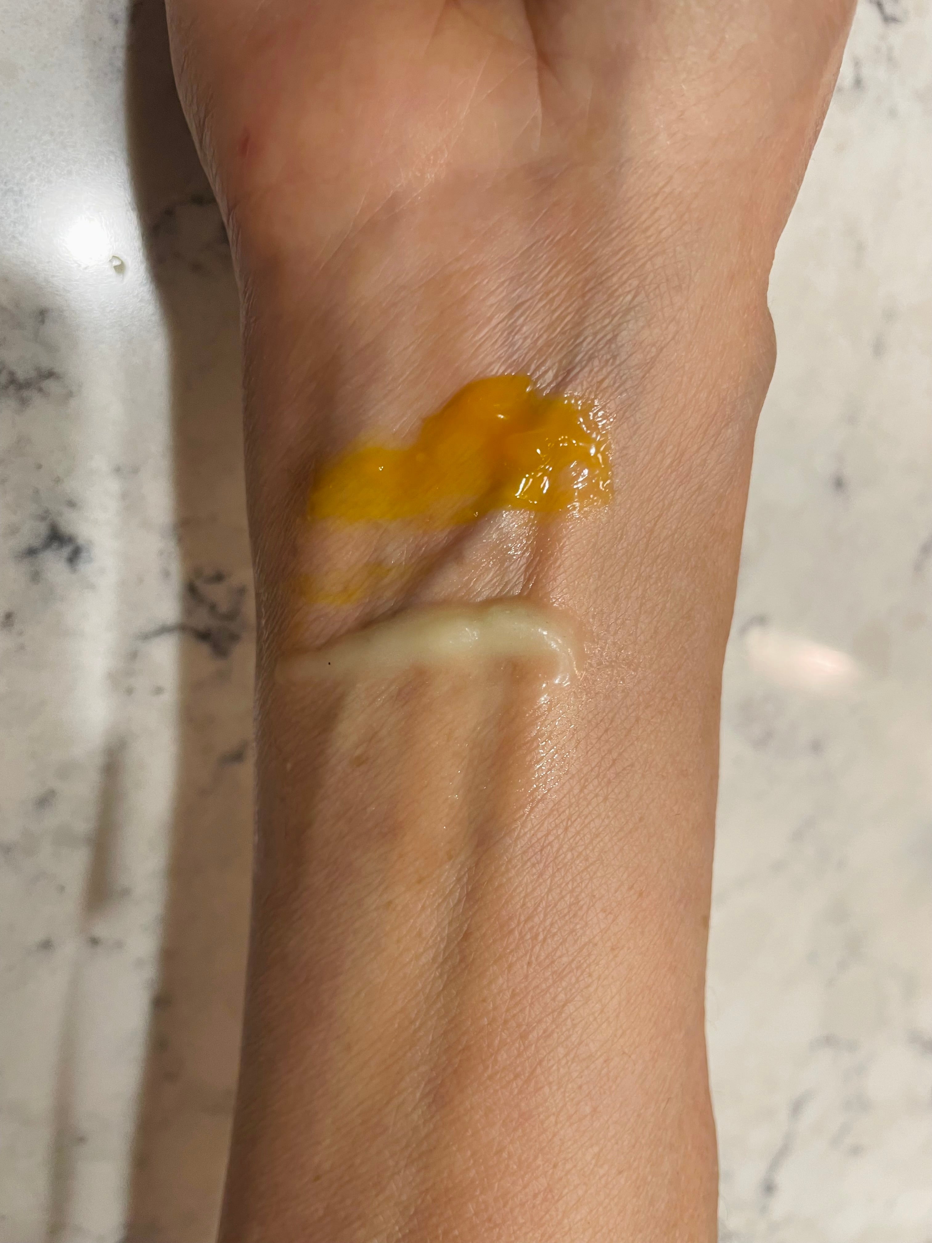 Arm of customer with swatches of cream and balm on her wrist. 